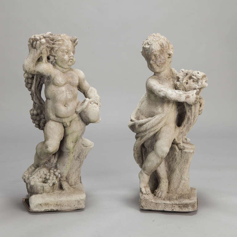 This pair of European stone garden statues were found in France and depict putti in classic form. One putto holds a jug and bunch of grapes while the other putto holds flowers. Natural wear to surface. Sold and priced as a pair.