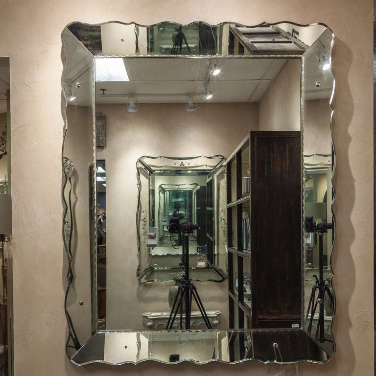 Circa 1940s Venetian style mirror can be hung horizontally or vertically. Mirror has mirrored frame with scalloped edge.