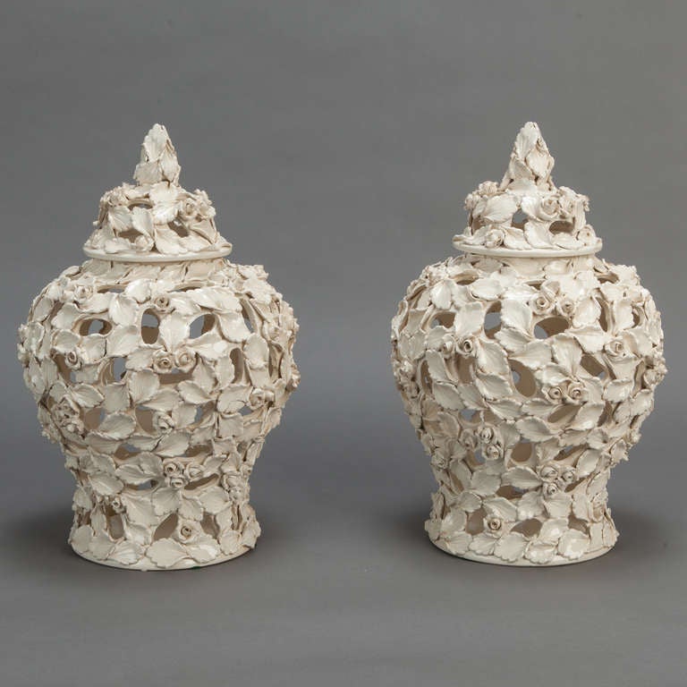 This pair of tall Italian covered mantle vases have open work forms of intricately detailed ceramic rose leaves and buds. Sold and priced as a pair.
