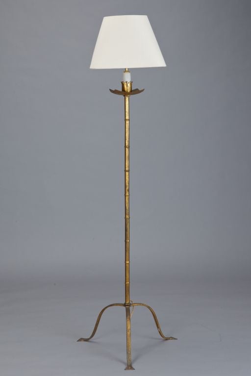 Circa 1920 Spanish gilded metal floor lamp with faux bamboo details and tripod base. Wired for US electrical standards. Height shown is to top of socket. Width shown is at base.