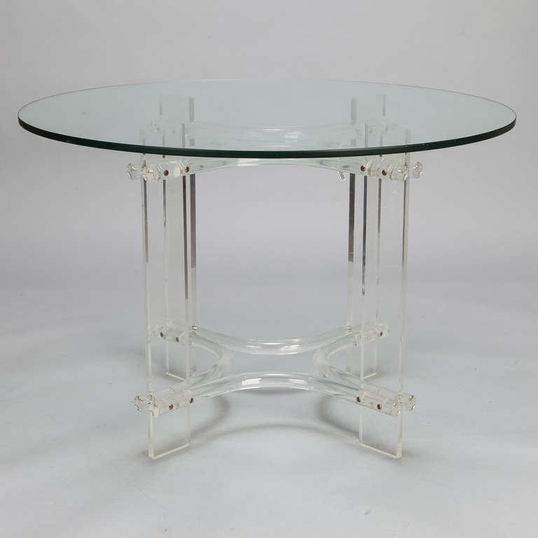 Circa 1970s mid century small dining/breakfast or center table with a clear lucite base and glass top.

Base:  31” w x 28” h x 31” d
Top:  43.75” diameter x .5” thick