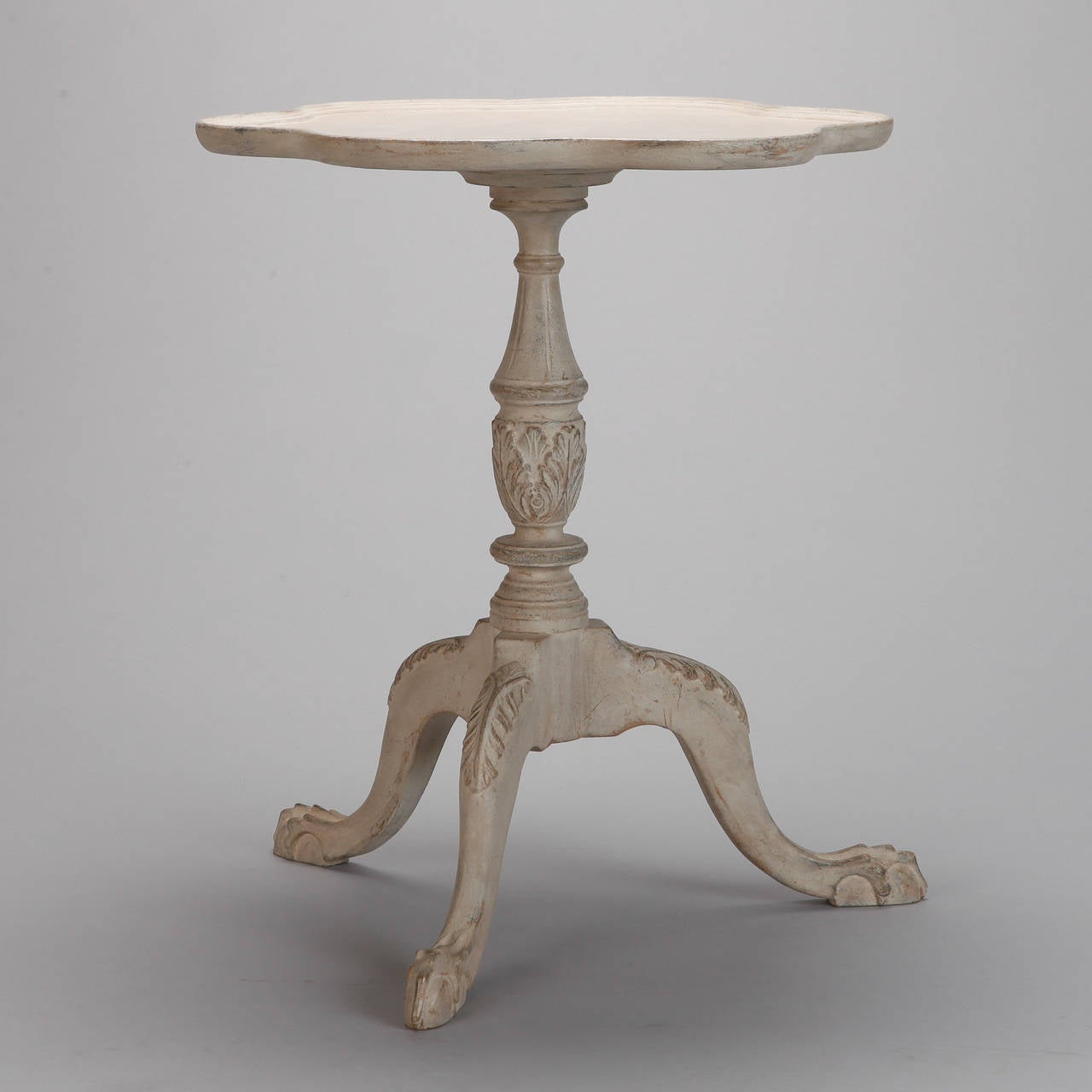 Circa 1900 French side table with a white painted finish, curved tripod base and round table top with scalloped edge.