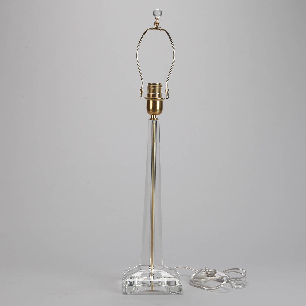 Circa 1970s tall, elegant clear glass Murano table lamp with brass fittings and center shaft in modified obelisk form with round square base. New wiring for US electrical standards.