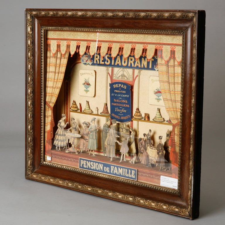 Circa 1880s French cut and colored paper diorama titled “Pension de Famille”. This charming piece depicts a 19th century guesthouse restaurant scene with ladies in elaborate dresses.  Original wood frame with gilded details. We also have another cut