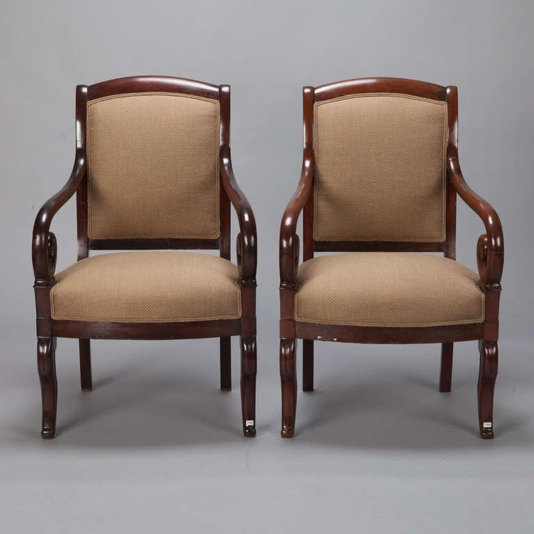 This pair of circa 1850 mahogany arm chairs have beautifully scrolled arms and curved legs and new upholstery in a neutral tan linen with double welting on the seats and backs. Arms are 24.25” high. Seats are 16.5” high and 18.25” deep. Sold and