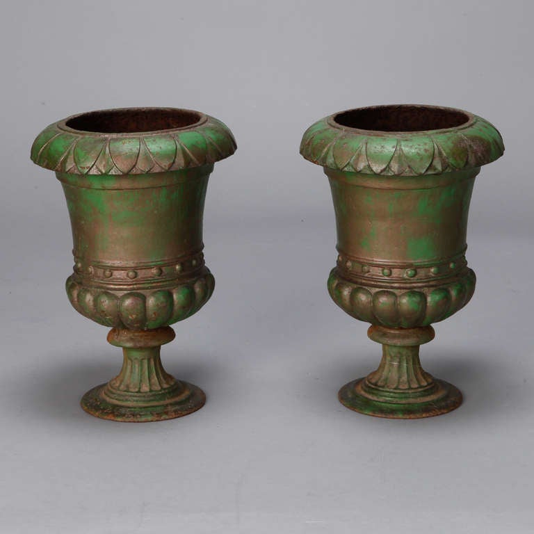 Use these classic 19th century French cast iron urns indoors or out. Original green finish shows patina and wear. Sold and priced as a pair.