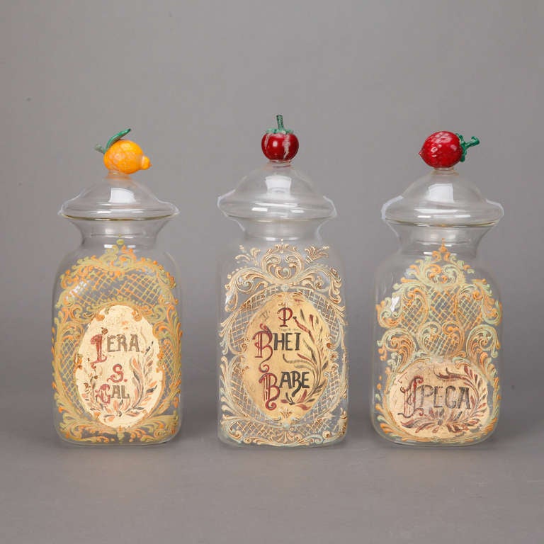 Large Venetian clear glass apothecary style jars with hand-painted labels and handblown, colored glass fruit on the lids, circa 1900. Sold and priced individually.