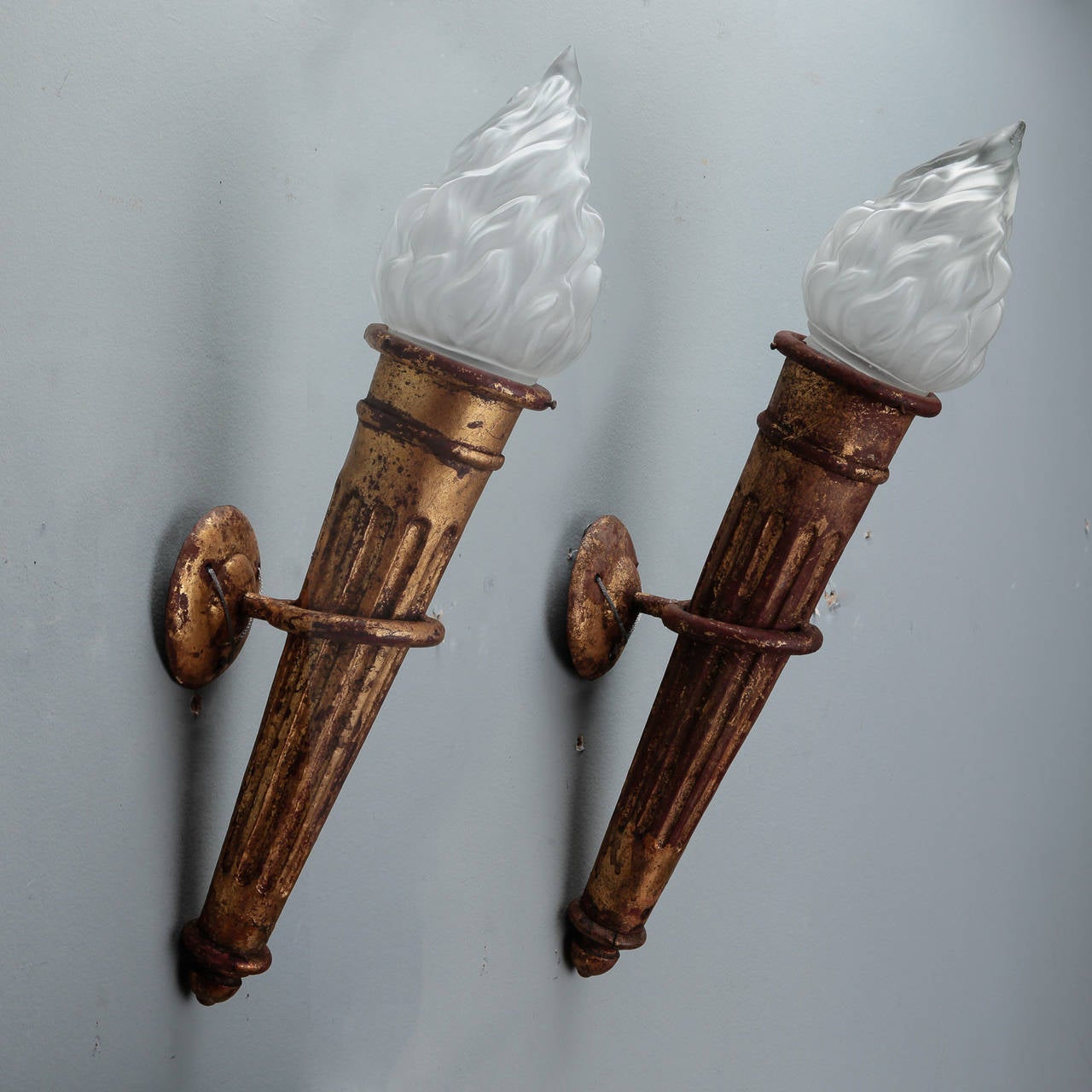 Circa 1900 pair of Spanish large gilt metal neoclassical style torch form wall lights / sconces. Topped with satin glass flame-shaped globes. Sold and priced as a pair. New wiring for US electrical standards.