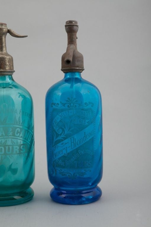 Several circa 1900 French soda fountain / syphon bottles available. Acid etched French labels and great colors - shades of blue, peach, clear and others are available. Metal syphon tops - these are a great alternative to apothecary jars. Sold and