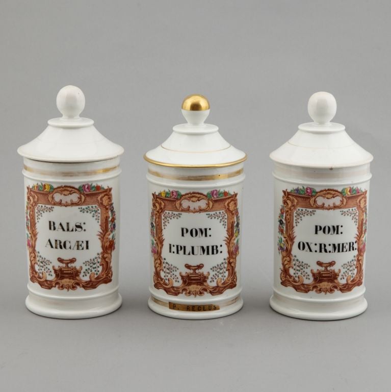 Two French white porcelain apothecary jars with Latin labels and lids. Sold and priced separately. One is labeled: BALS: ARCAEI and the bottom marked PEIGNEY. The jar with gilded lid is labeled POM: I:PLUMB: and is marked PEIGNEY on bottom. The