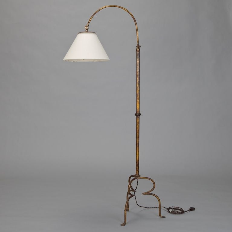 Circa 1920s Spanish floor lamp is made of gilded metal with graceful, curved lines and and a curved tri-foot base.  Newly wired for US electrical standards.