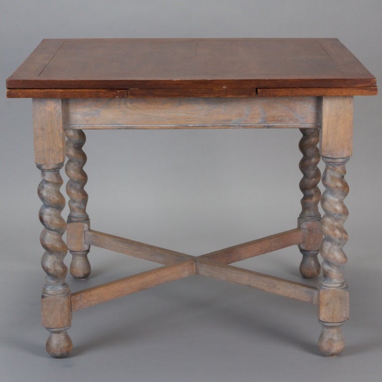 Circa 1920 English refractory table has a whitewash base with crossed stretchers and substantial barley twist legs, wood stained top. Width with leaves extended is 59”, without is 35.5