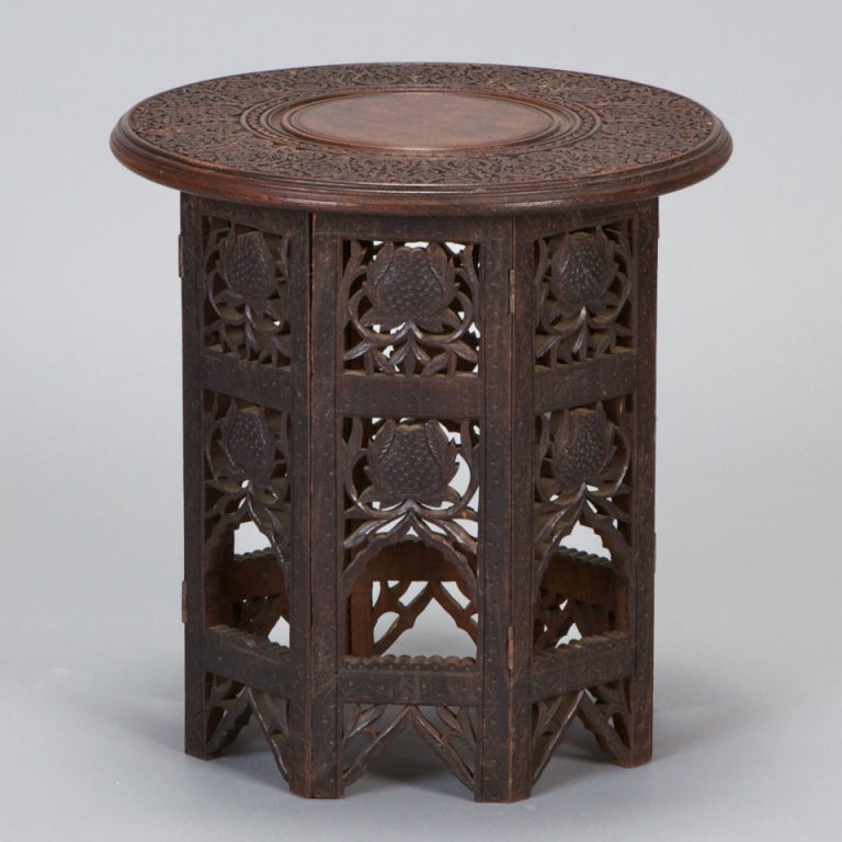 Carved Turkish or Moroccan table has a round, removable top with detailed carving and eight-sided open work carved base. Base panels are hinged and top lifts off so base can be folded flat for easy shipping or storage. We have other similar