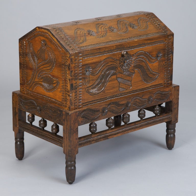 Carved wood Pennsylvania Dutch dowry chest and matching stand. Chest has domed hinged lid and decorative floral carvings on all panels. Stand has decorative turned knobs and floral carved details.