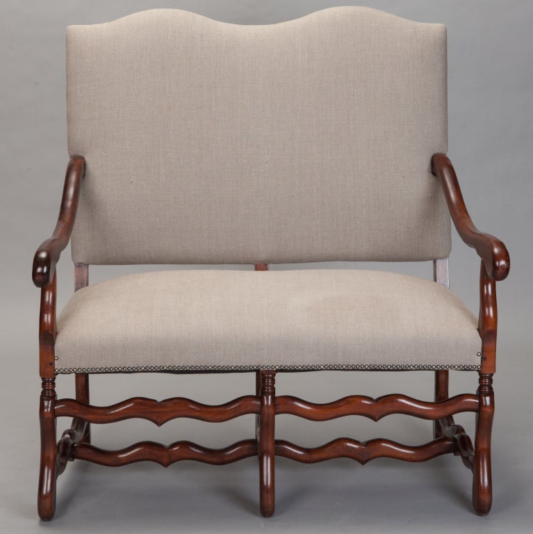 Circa 1920 Os De Mouton settee has handsome wood frame with classic styling and new upholstery in beige linen with brass nailhead trim along the edges.
Arm Height:  26.5”
Seat Height:  20”
Seat Depth:  19.5”