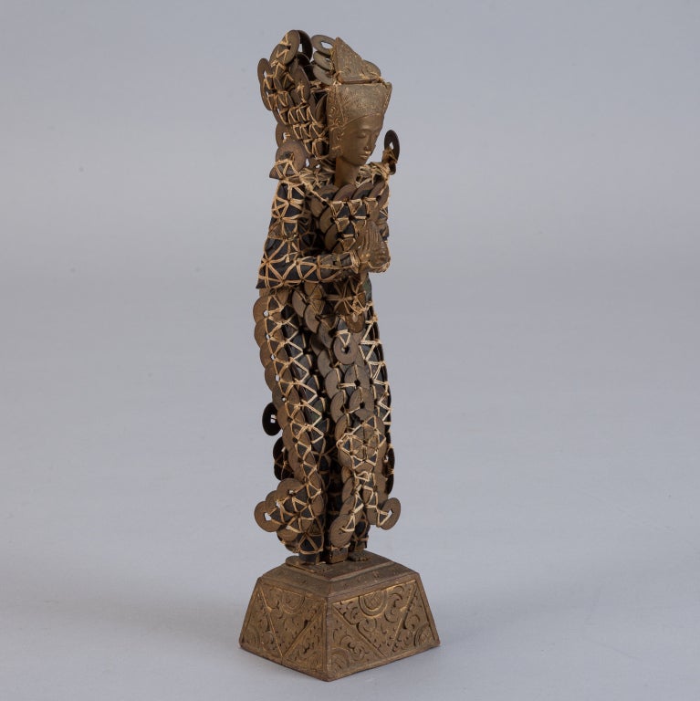 Long out of circulation, the ancient Asian coins that make up this figure still play an important role in Balinese cultural celebrations. For hundreds of years, a handful of Balinese families formed these statues by hand tying coins with reeds.