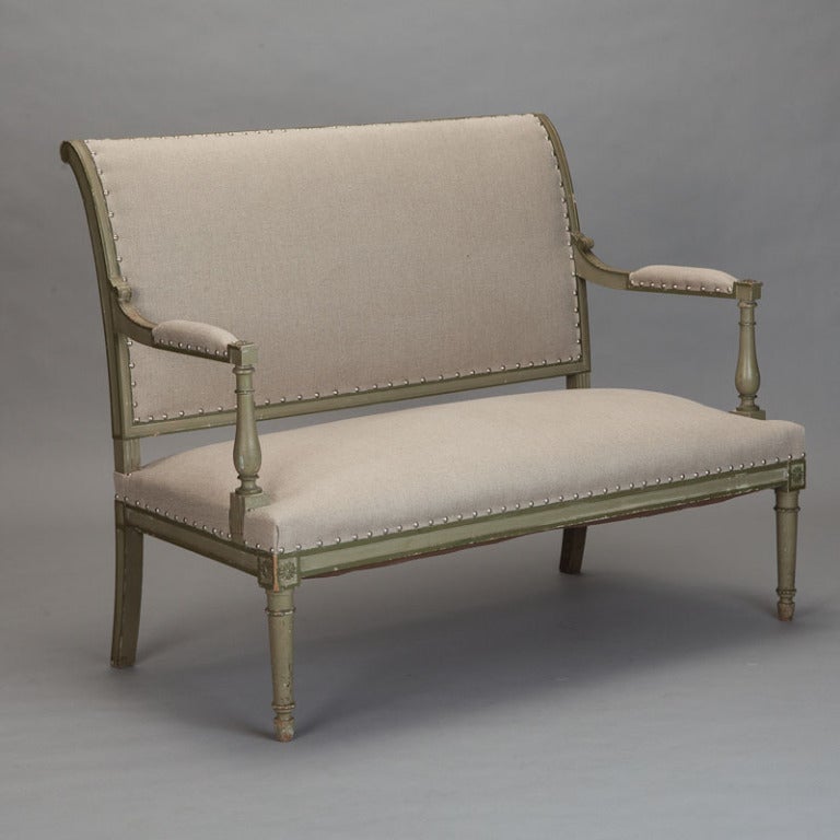 Circa 1900 Empire style carved and upholstered French settee. Antique green painted finish and newly upholstered in a neutral beige linen.
Arm Height:  25.5”
Seat Height:  18”
Seat Depth:  23”