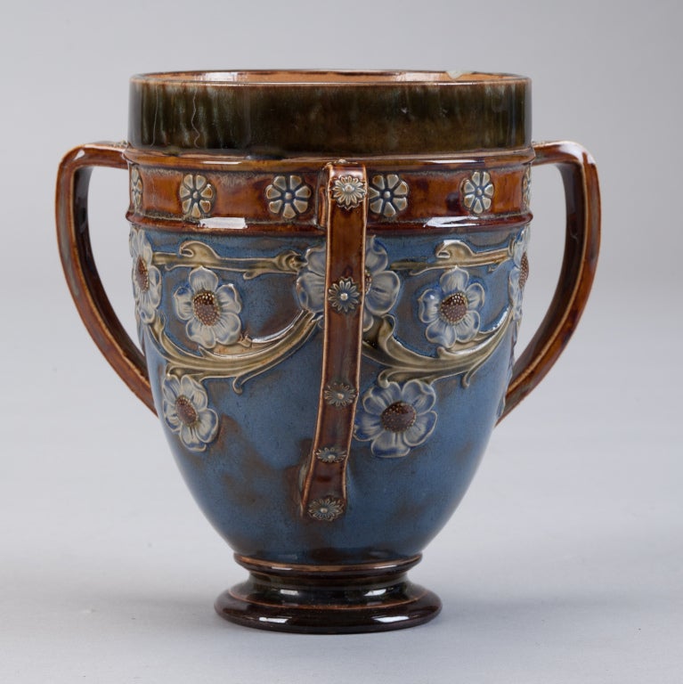 Late 19th century Doulton Lambeth tri-handled vase with blue and brown floral glaze.