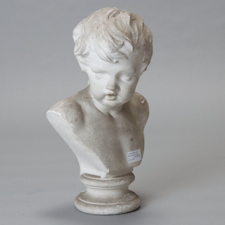 Turn of the century plaster bust of a young boy with a white finish.