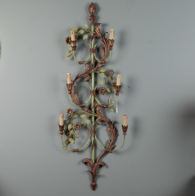This pair of very tall circa 1920s French six-light tole sconces have a design of acanthus leaves and flowering vines with a green and gilt painted finish. Some patina and signs of wear to painted and gilded finish. The wiring has been updated for
