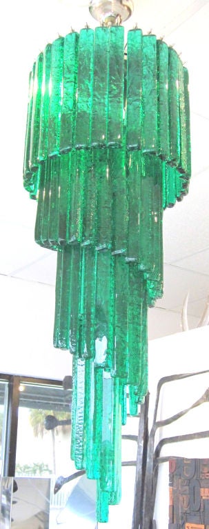 A unique, custom made, emerald green cast glass, four tiered chandelier, by Mazzega. Absolutely breathtaking!