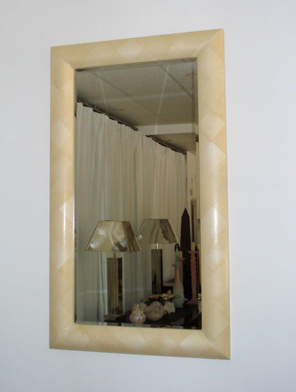 Ivory goatskin parchment cover the frame in a losange pattern with gorgeous corner cuts creating an extremely sleek mirror.