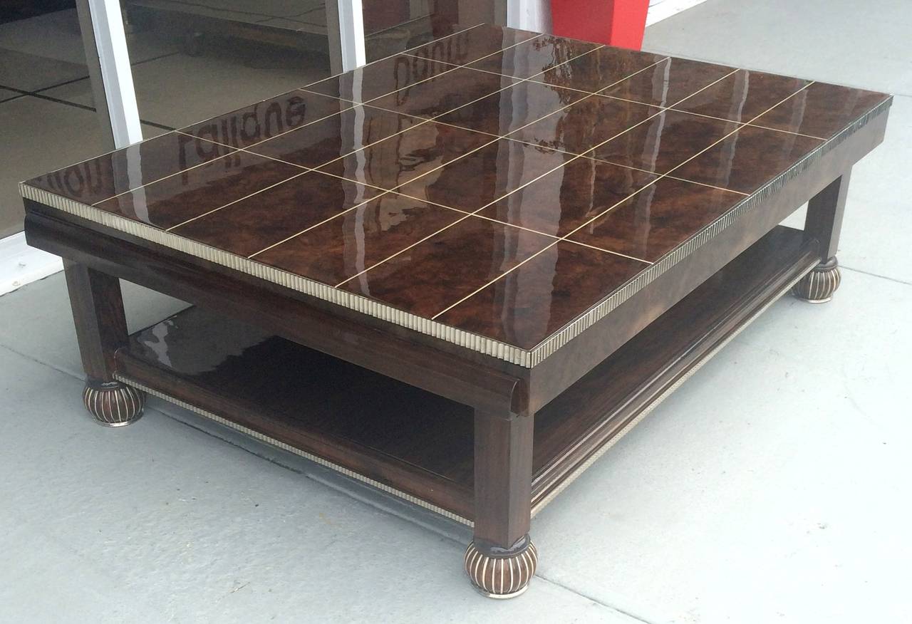 A sublime custom French Art Deco Christian Krass large coffee table in crotch mahogany wood with high gloss polish, nickel dipped hand grooved trim and nickel dipped bronze inlay and caps. The size is rare in the Art Deco era!