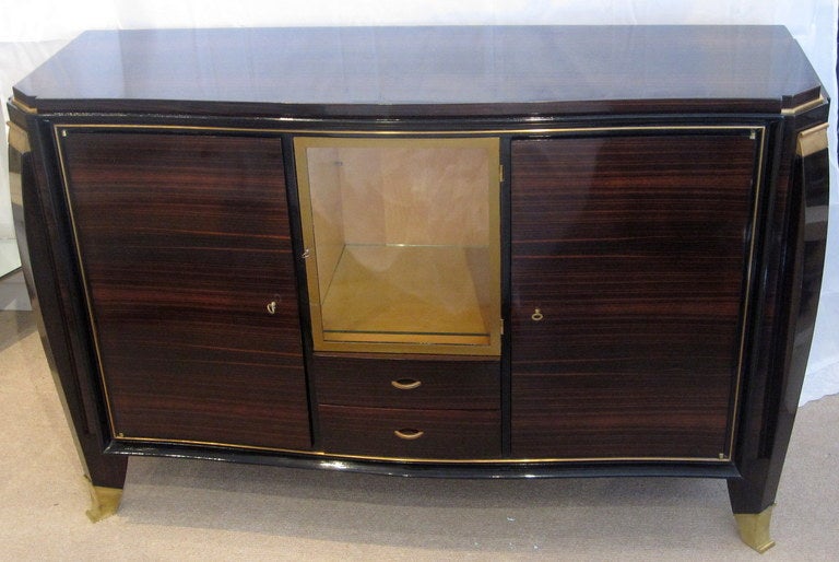 Very sleek French Art Deco Sideboard of Macassar wood with bronze accents by Maurice Rinck who had his workshop on Rue du Faubourg St. Antoine for the prestigious Rhulmann house. The Rhulmann influence can be felt on this piece with the gilt bronze