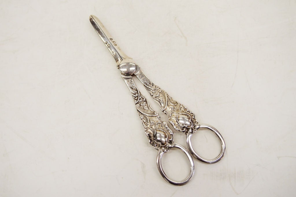 A cast Sterling Silver Grape Shears from England.  Decorated handles with empty cartouches (for engraving). Weight: 83 grams<br />
Fully hallmarked.