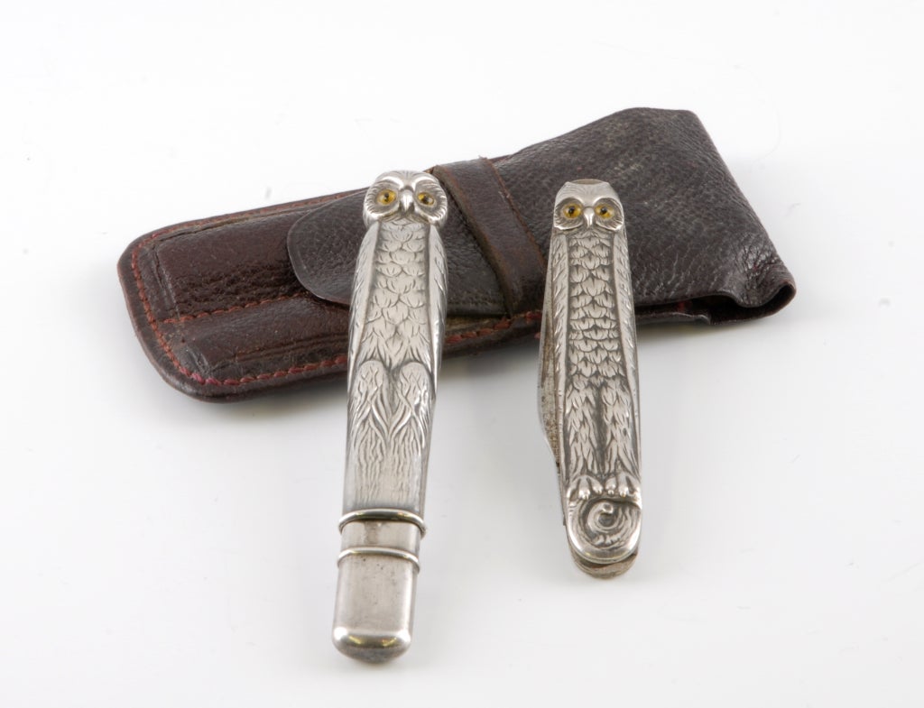 A Continental Silver (.800) Pencil and Penknife Set fashioned in the shape and design of Owls complete with coloured glass eyes.  They both come with their original morocco leather carrying case.