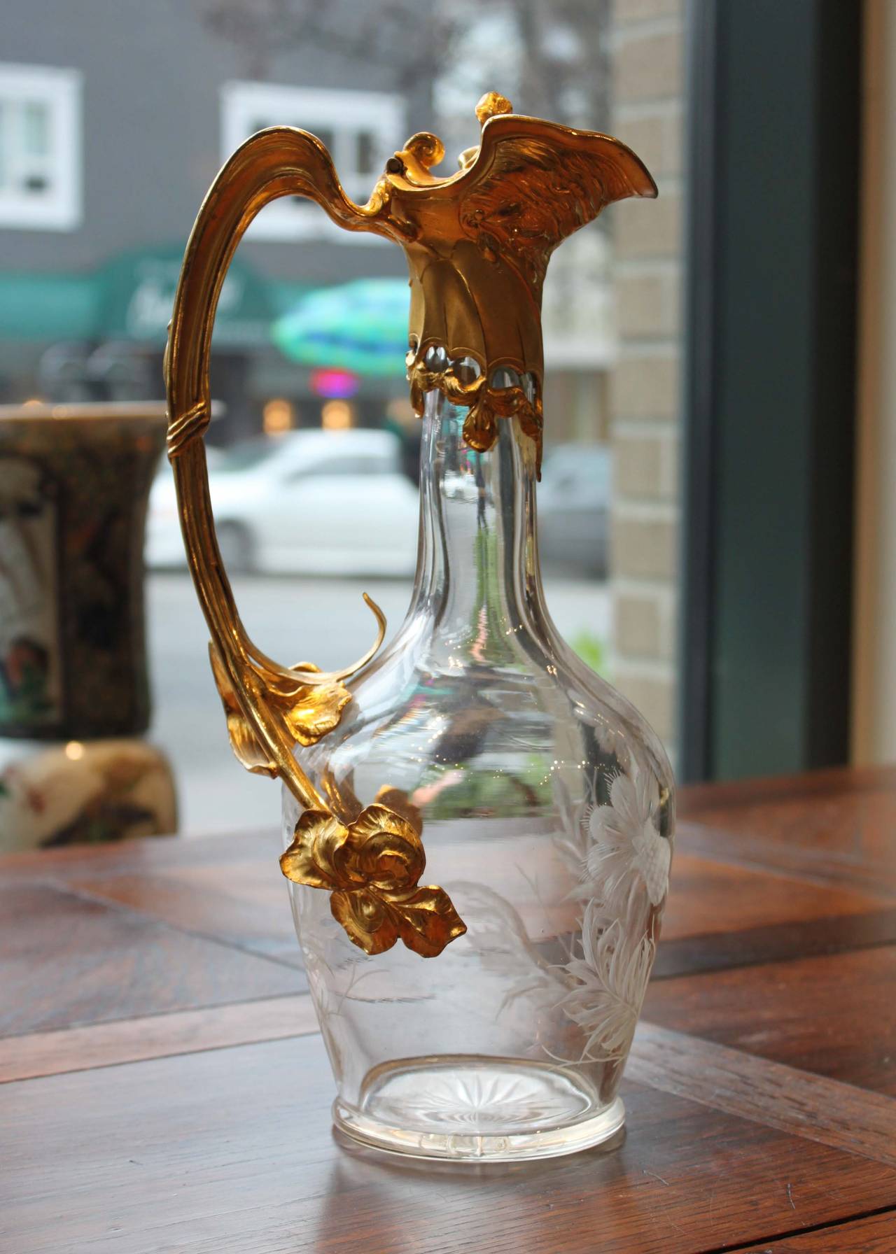 A beautiful Art Nouveau decanter with gilt gold handle. Organic lines typical of the period flourish and seem to grow around the etched glass vessel. Original condition.