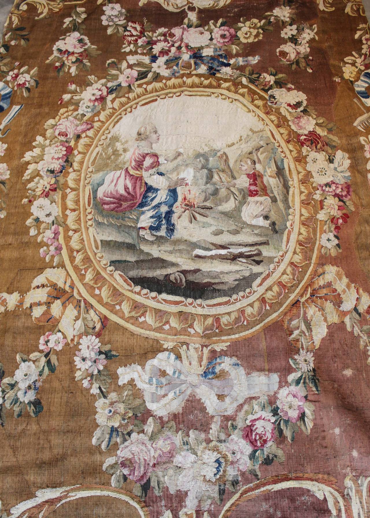 Original 18th century Aubusson tapestry. Figures depict a scene around a fire in the outdoors, encircled by stylized foliage and floral motifs. Inquire for condition.
Panache Antiques.