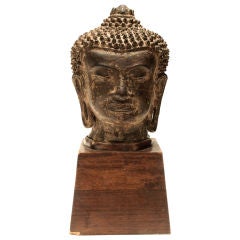 Asian bronze Buddha head on wooden stand