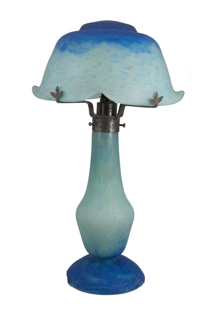 DAUM 
TABLE LAMP, CIRCA 1910 
glass, internally decorated in shades of blues and turqoise,
with domed shade and baluster shaped base, signed on shade Daum 
14½ in (36.8cm) high 
engraved mark Daum 