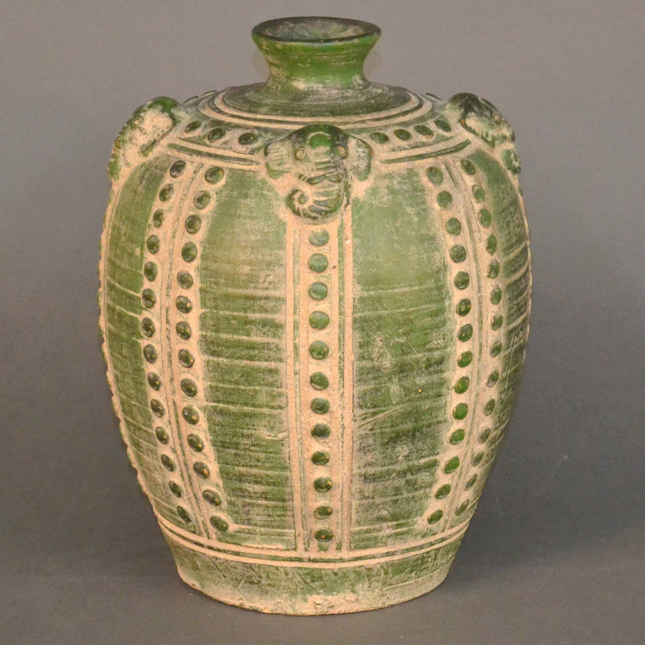Large dark emerald green and sand colored surface. Decorated with elephant heads and rows of circles.