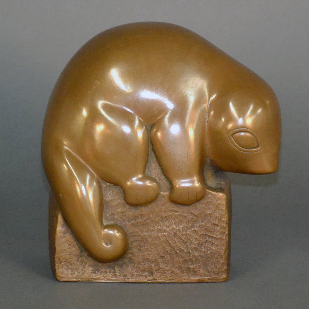 A charming composite cast American sculpture of a baby opossum resting on a hammered block, copyright edition no longer in production, signed Marion Weisberg. The bronze finish of this sculpture has a beautiful warm patina.