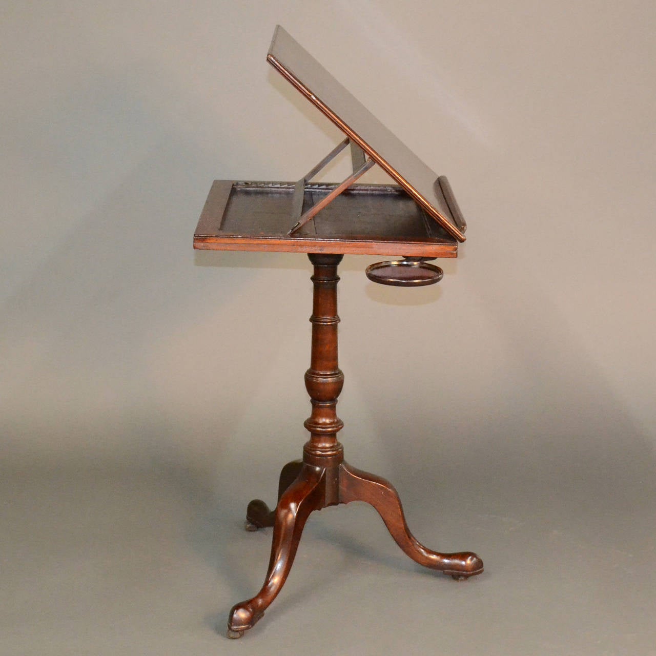 A fantastic antique George III mahogany reading stand with pull-out candle slides or supports. This reading stand has a beautiful patina and is truly an elegant piece of history. The top is adjustable to accommodate different reading heights and the