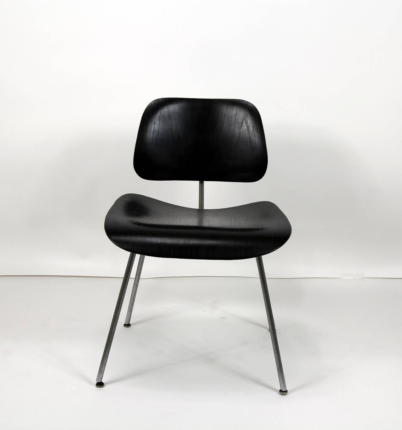 Set of four Eames DCM dining or desk chairs with chrome frame in ebony finish. In good condition with some replaced hardware.