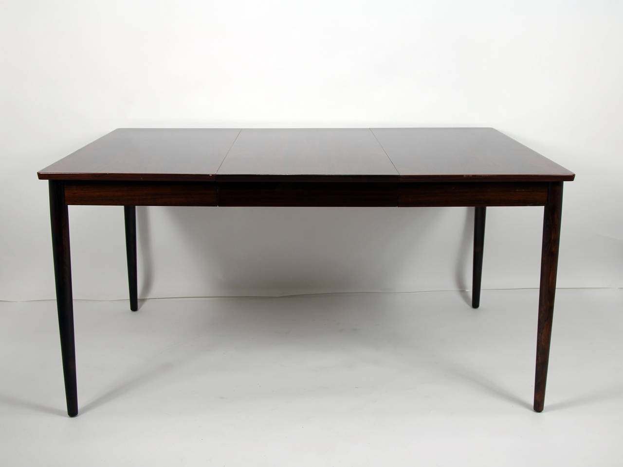 Svend Langkilde rosewood dining table. Danish modern rosewood table with two leaves. Designed by Svend Langkilde. Reduces down to card table side. Ideal for apartment.