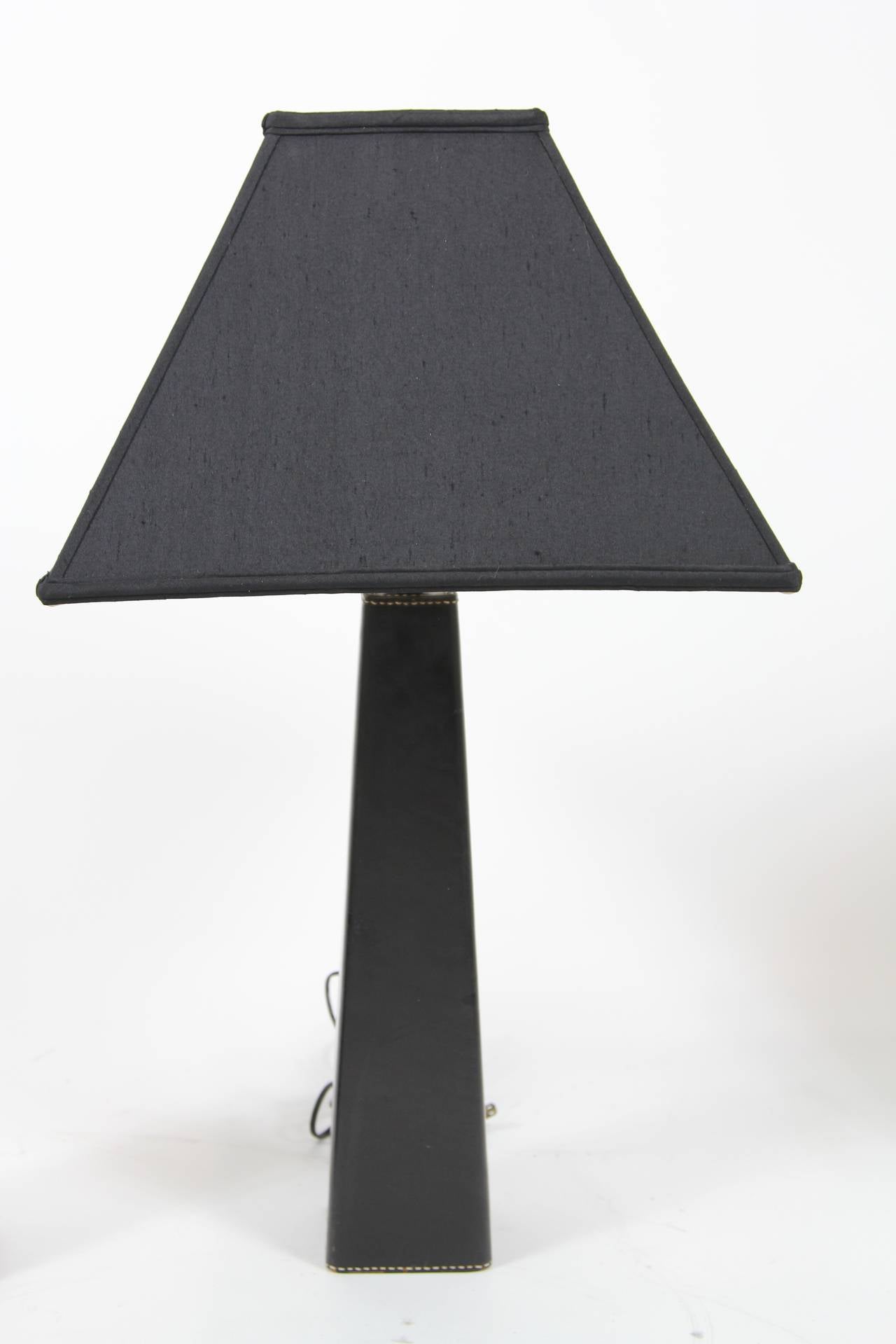 Fabulous and unique artist-made lamps make a dramatic statement in a great room, office or study. One is black leather, the other is black/tan leather, both top-stitched in the back. Marked Denmark on bottom. New black hand-tailored square-edge