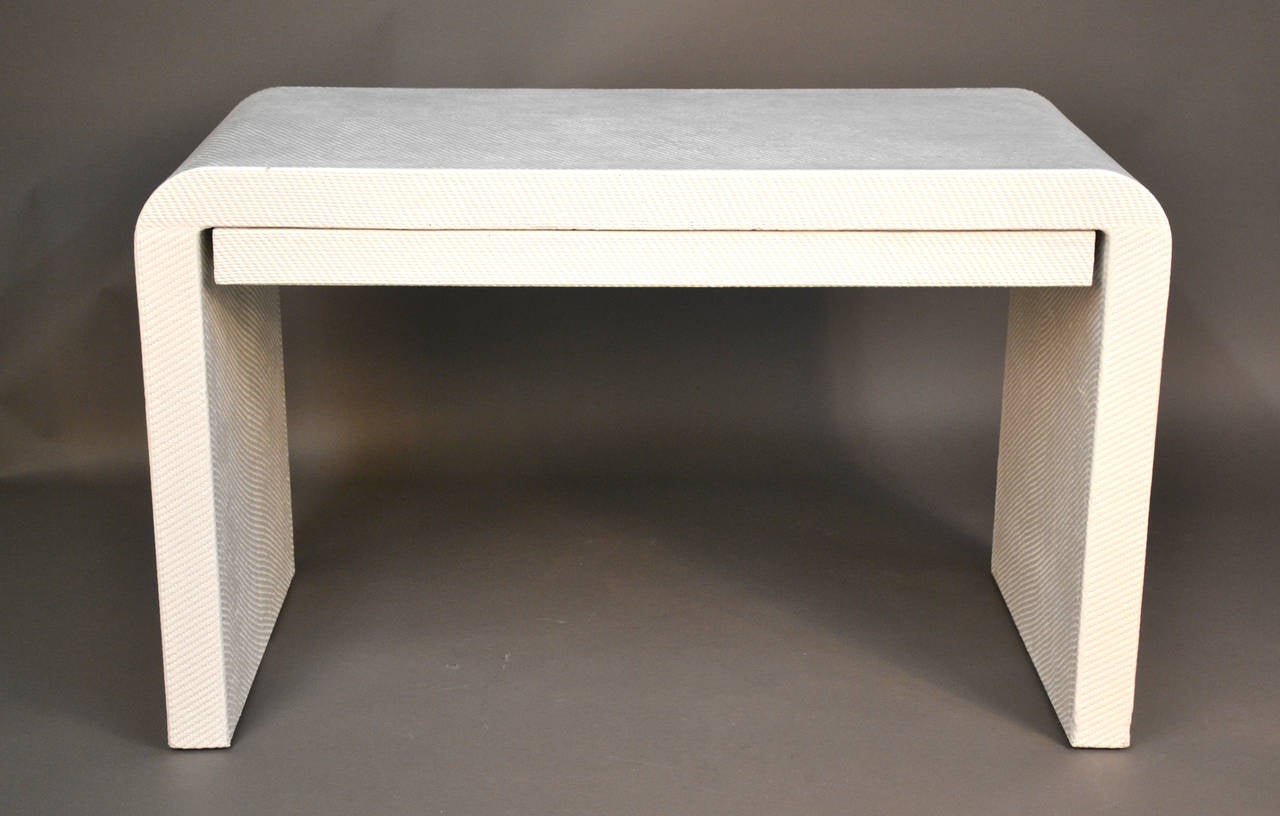 This waterfall vanity has a textured finish wrap. Has one thin drawer and has been newly lacquered white.