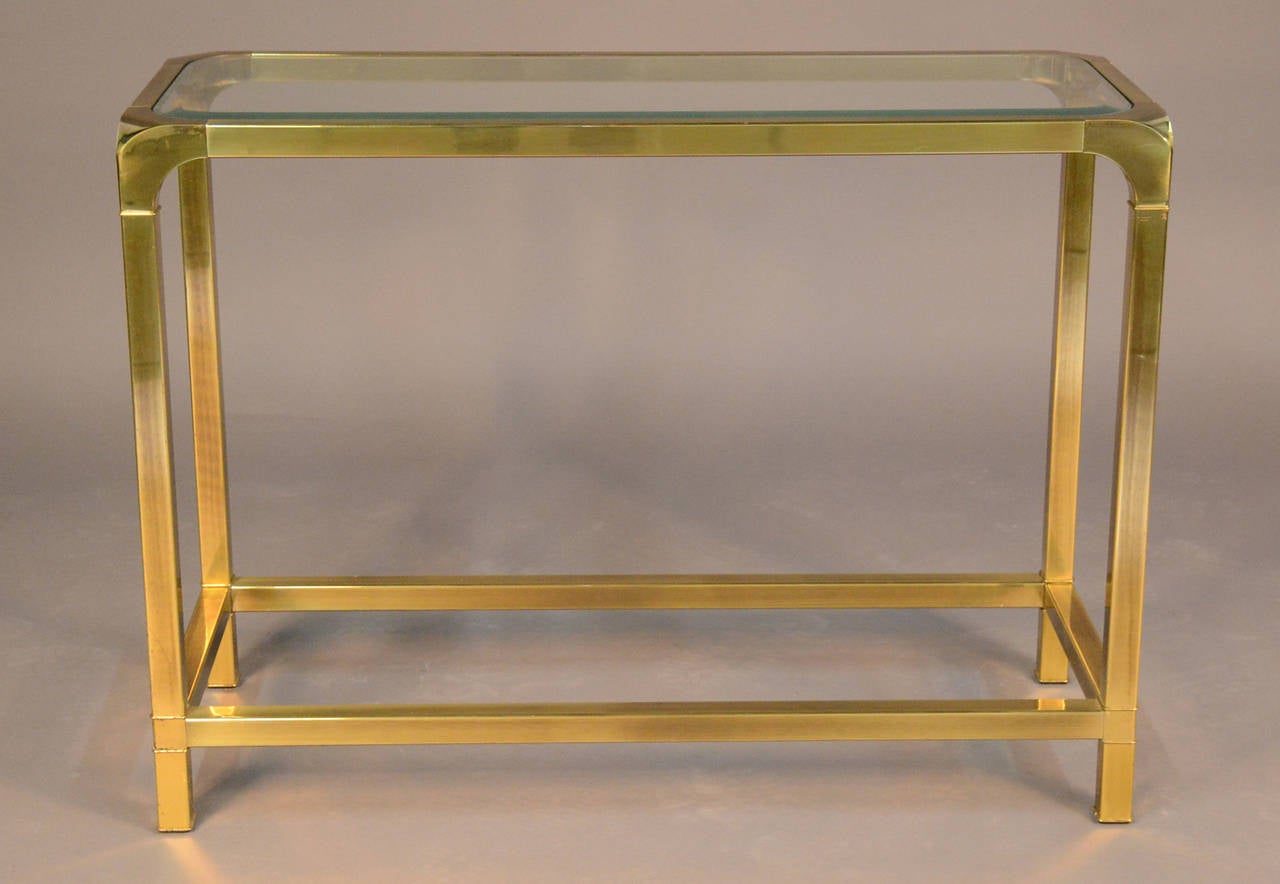 Beautiful brass console table with glass shelf by Mastercraft. Beveled glass and brass corners.