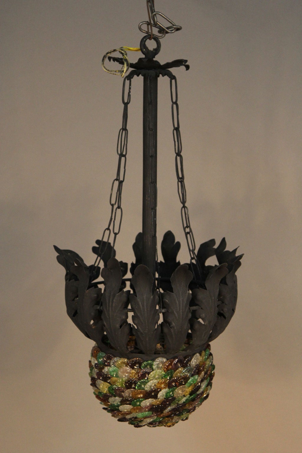 Rare matching pair of Archimede Seguso chandeliers, featuring handblown glass flowers in shades of green, purple, amber and clear, wired to a basket (approximately 10 inches in diameter and 6 inches deep). 
Each basket is affixed to a black metal