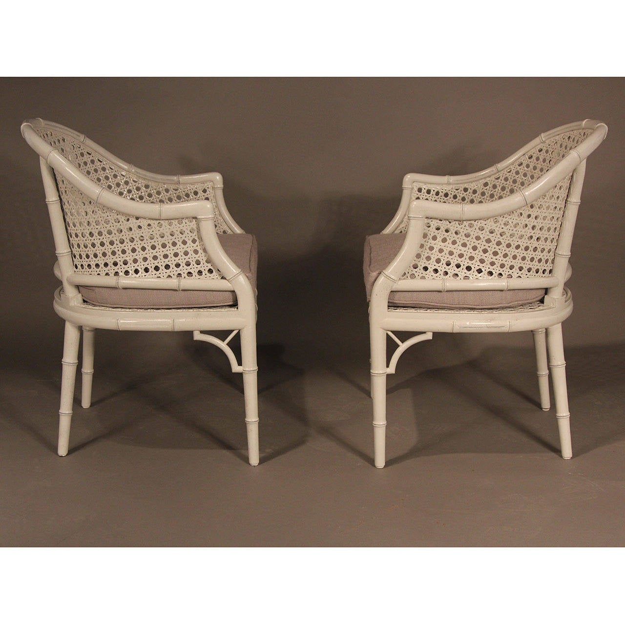Pair of beautifully restored pale gray painted barrel back chairs with darker gray accents. Possibly Henredon. New gray muslin covered cushions.
