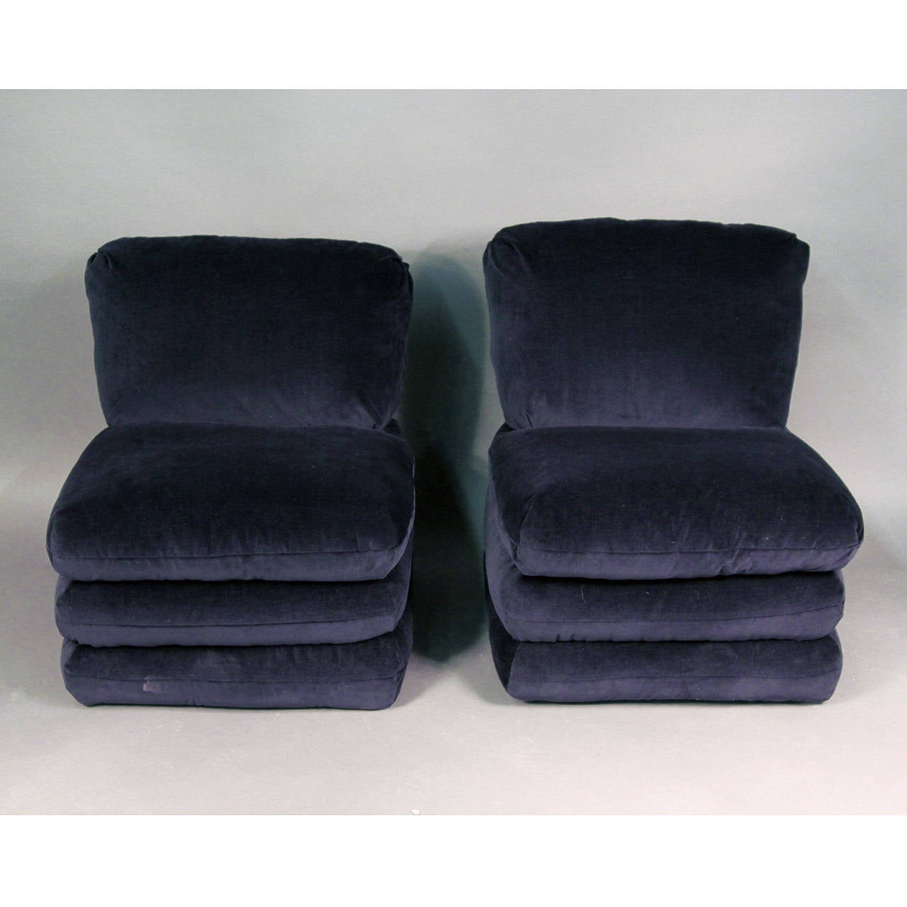 Absolutely stunning pair of navy velvet slipper chairs, early Donghia design for Vice Versa. Original tag intact on base. Unusual and rare shape, in excellent newly reupholstered condition (in plush Stark cotton velvet).