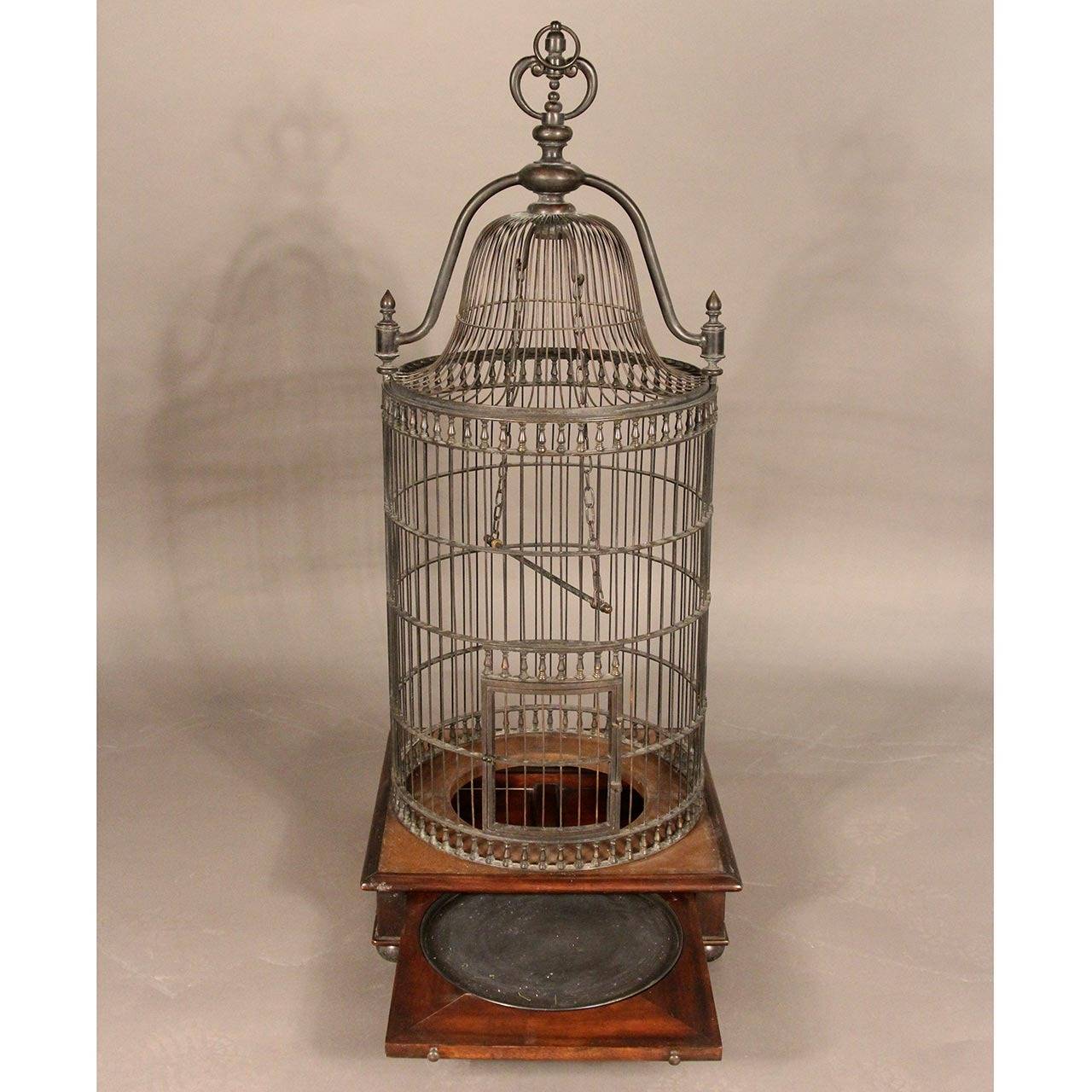 Unique, large bronze bird cage. Mounted on two-drawer, tooled leather and wood base. With ball feet and foliate bronze knobs.