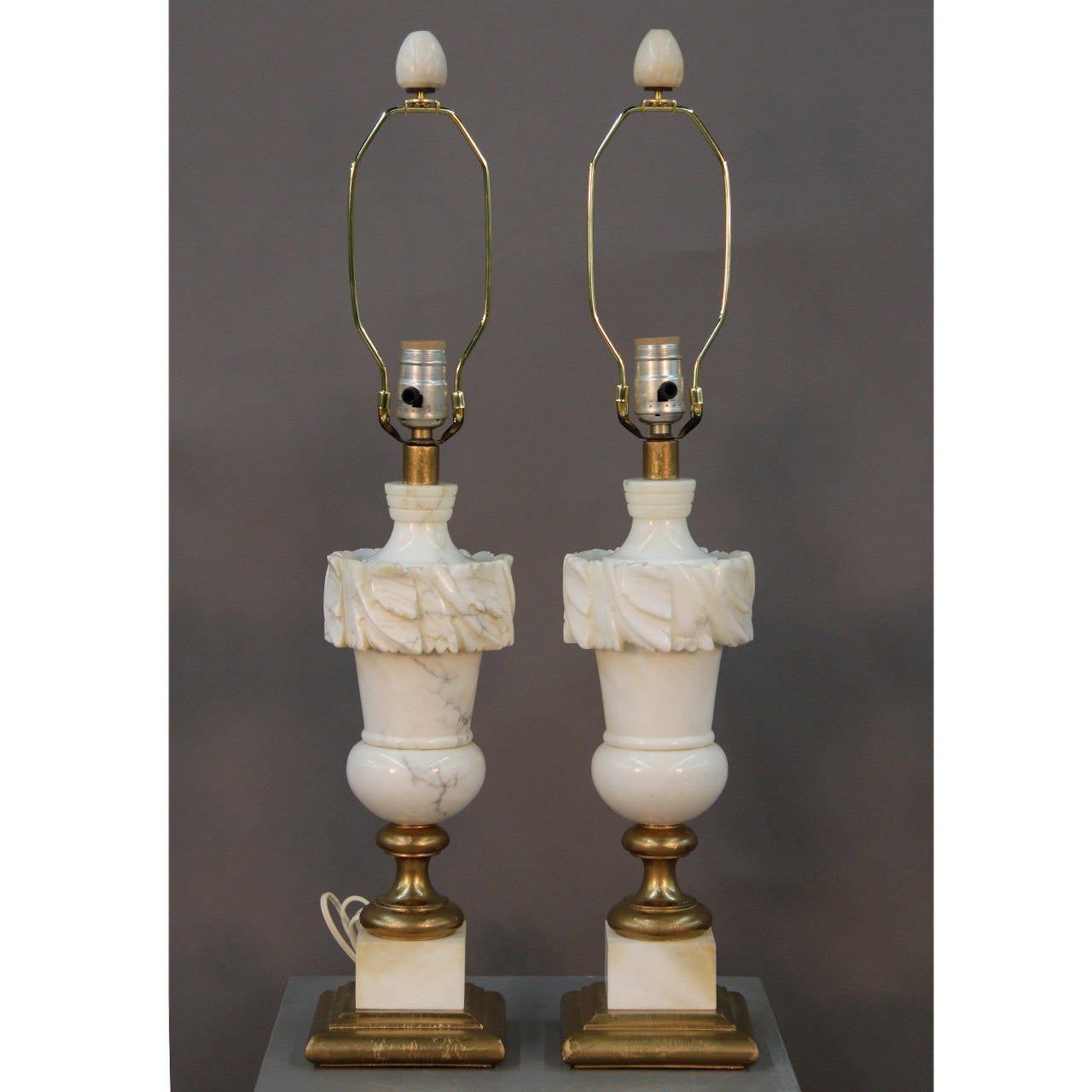 Elegant, beautifully proportioned vintage alabaster lamps with carved leaf design and original alabaster finials. Gilded wood base. Fitted with new natural linen cut corner shades.