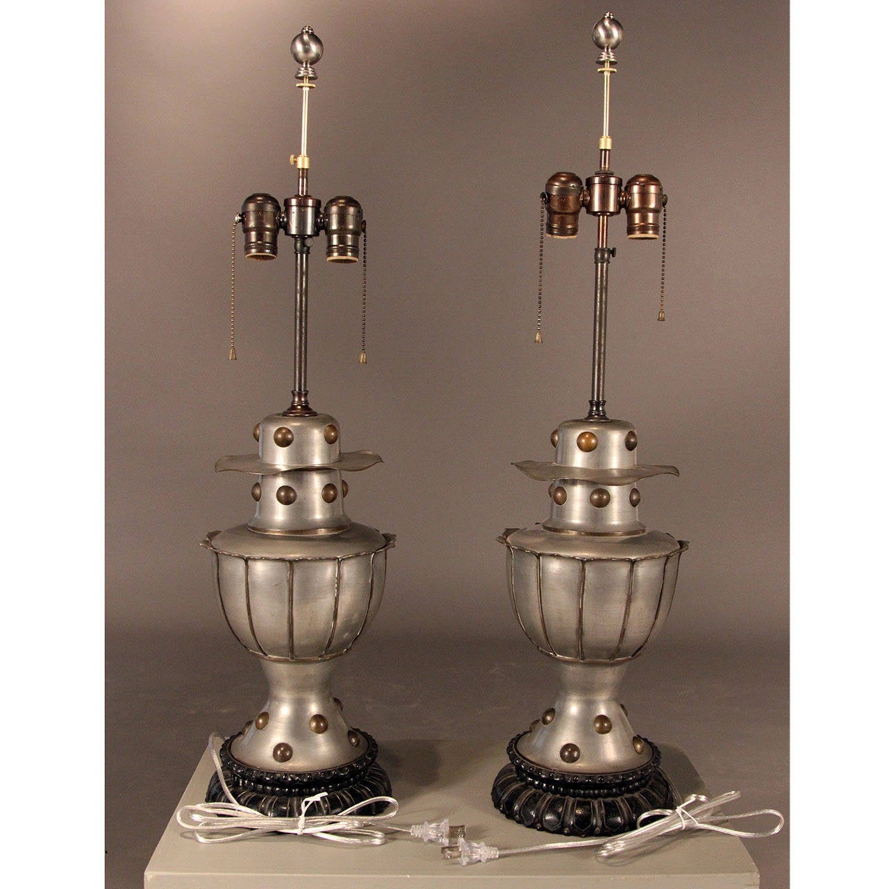 Exquisitely crafted pewter lamps with brass accents and carved wood bases in overall fabulous condition. Impressive size and distinctive armorial design make an elegant and dramatic statement.