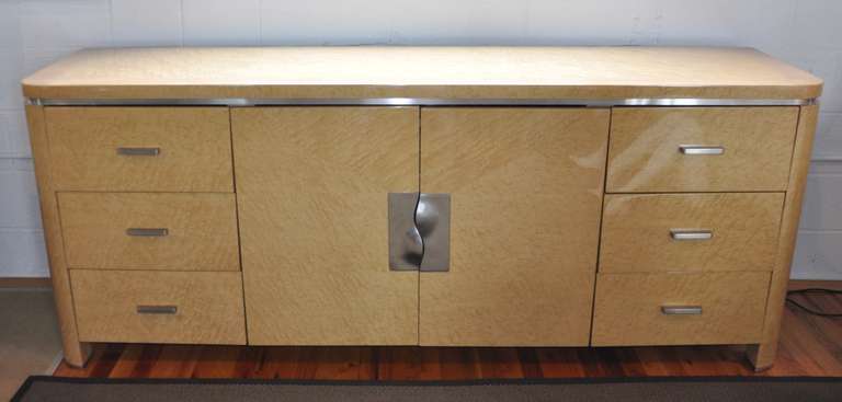 Exceptional Art Deco dresser or buffet by Giorgio Collection. In polyester coated bird's-eye maple, stainless handles. Six drawers and opens to glass interior drawer and shelf. Note crack to glaze, note handles.