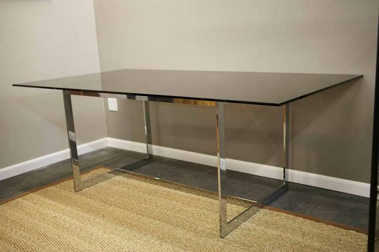 Beautiful, simple and elegant Milo Baughman dining table with thick glass top in chromed steel.